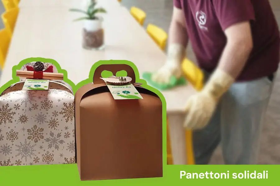 Panettoni in primo piano e Giuseppe che pulisce il tavolo
